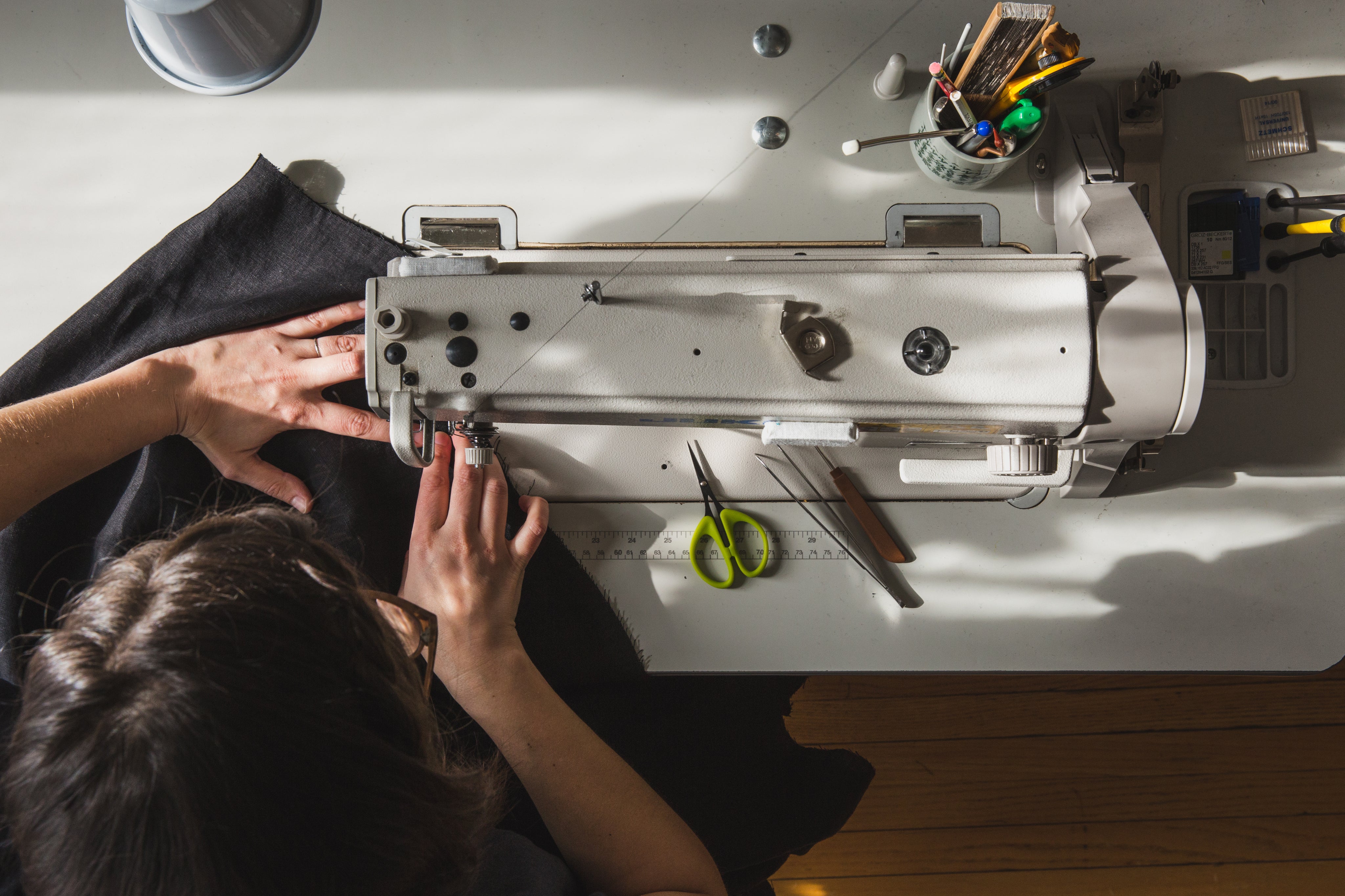 Woman sewing sun protection garment on an industrial machine, representing Ondine’s sun protection clothing craftsmanship
