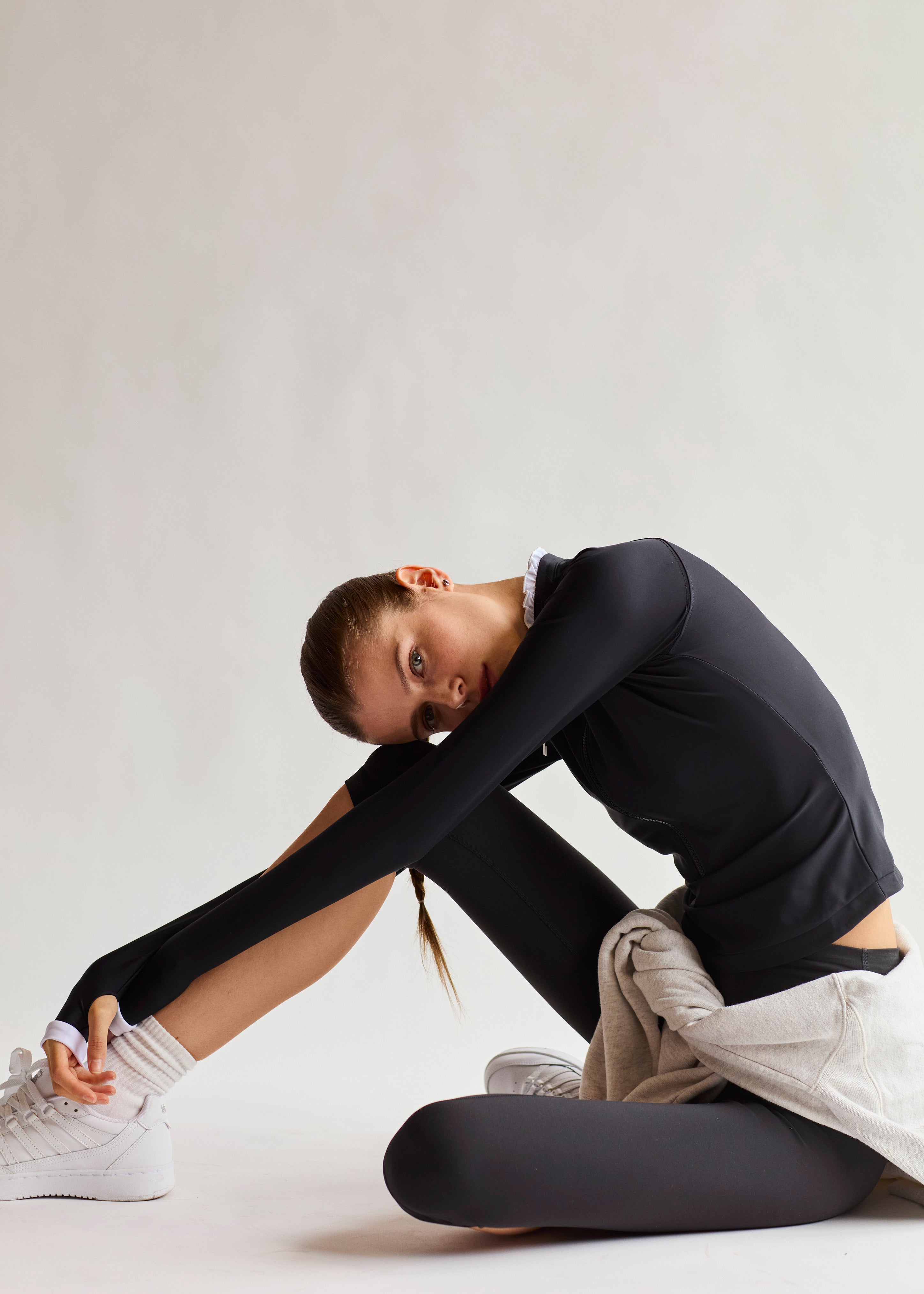 Model stretching in Chloé Rash Guard UPF 50+ by Ondine, showcasing flexible fit and athletic elegance.